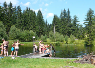 Kinder gehen im Teich schwimmen